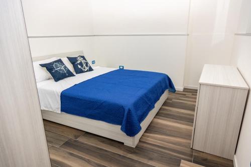 ein Schlafzimmer mit einem Bett mit einer blauen Decke in der Unterkunft La Casa di Anna in Bagheria