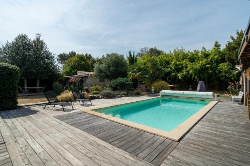 - une piscine dans une cour avec une terrasse en bois dans l'établissement Villa Saint Jean - Maison avec piscine privée, à Saint-Jean-dʼIllac