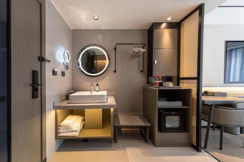 a bathroom with a sink and a mirror at Gongxili - Xige Hotel in Chengdu