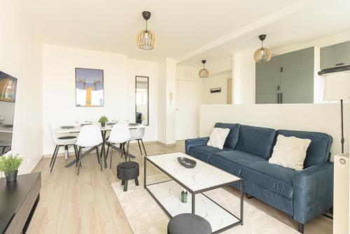 un salon avec un canapé bleu et une table dans l'établissement Disneyland Family Residence, à Montévrain