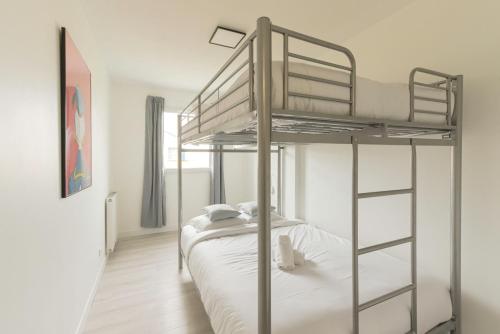 a bedroom with a bunk bed with white sheets at Mickey Appartement - Next to Disneyland in Montévrain