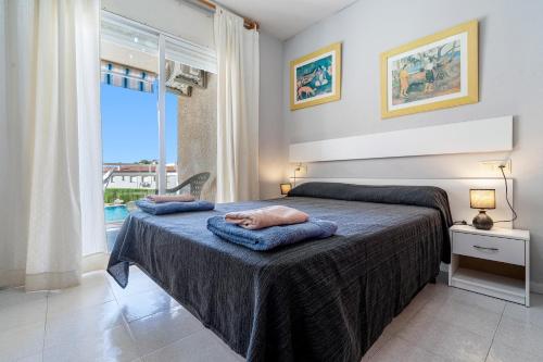 a bedroom with a bed with two towels on it at Residencial Los Pelicanos in Hospitalet de l'Infant