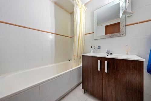 a bathroom with a sink and a bath tub at Residencial Los Pelicanos in Hospitalet de l'Infant