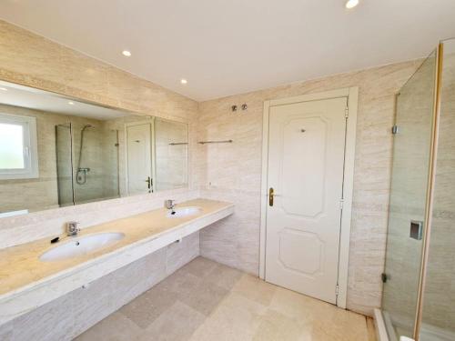 La salle de bains est pourvue de 2 lavabos et d'un grand miroir. dans l'établissement The best Villa in Los Flamencos, à Mijas