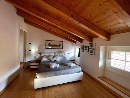 a bedroom with a bed and a wooden ceiling at Plinio center town apartment in Bellagio