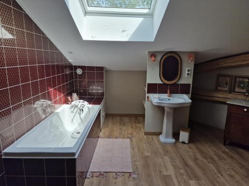 La salle de bains est pourvue d'un lavabo, d'une baignoire et de toilettes. dans l'établissement Chambre de charme dans maison de maître, à Montauban