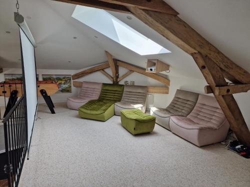 ein Wohnzimmer im Dachgeschoss mit Sofas und einem Dachfenster in der Unterkunft Chambre de charme dans maison de maître in Montauban
