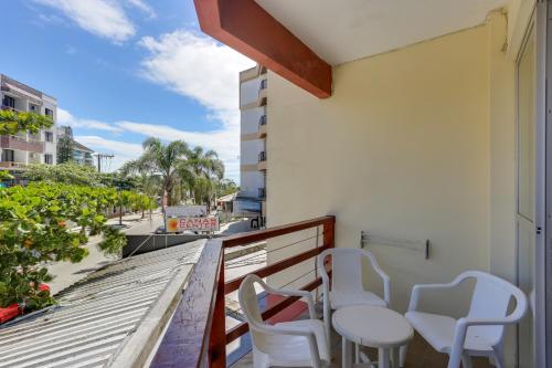 balkon z 2 krzesłami i stołem w budynku w obiekcie Canascenter Apart Hotel w mieście Florianópolis