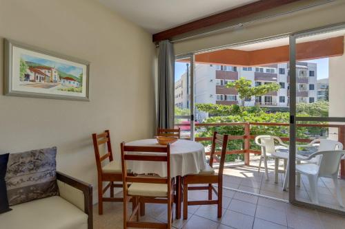 a dining room with a table and chairs and a balcony at Canascenter Apart Hotel in Florianópolis