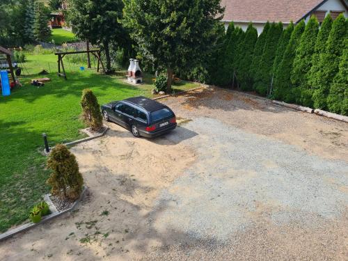 a car parked in a parking lot in a yard at Noclegi Pod Modrzewiem in Powidz