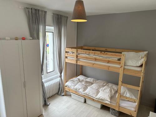 a bedroom with bunk beds in a room with a window at Villa Stella 8pers. La Bourboule in La Bourboule