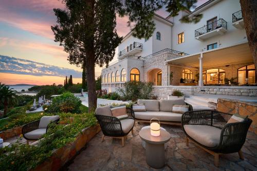 a house with a patio with chairs and a couch at Hotel Moeesy, Blue & Green Oasis in Hvar