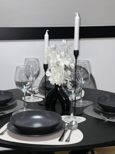 a black table with plates and glasses and candles at MANGATA in Pale