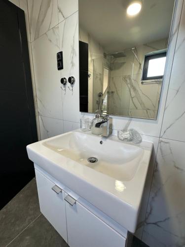 a bathroom with a white sink and a mirror at MANGATA in Pale