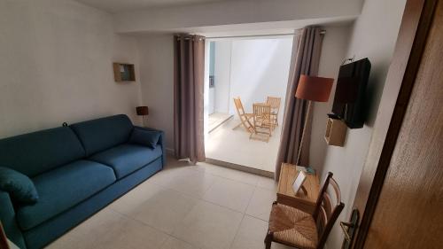 un salon avec un canapé bleu et un balcon dans l'établissement Appartement calme centre ville à 80m des Halles, à Narbonne