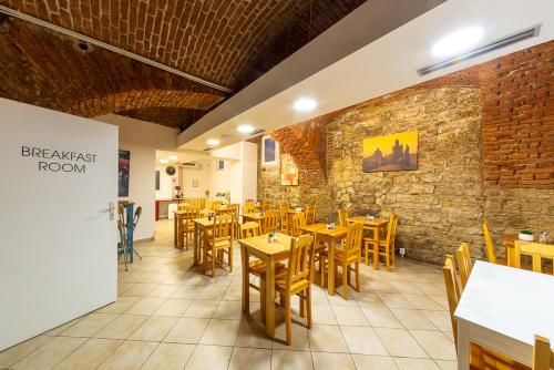 a restaurant with wooden tables and chairs and a brick wall at Minimino hotel in Prague