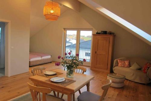 Una sala de estar con una mesa y sillas y un sofá. en Ferienwohnung Manu, en Kisslegg