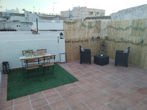 un patio con mesa y sillas en la azotea en Apartamentos La Campana 1, en Jerez de la Frontera