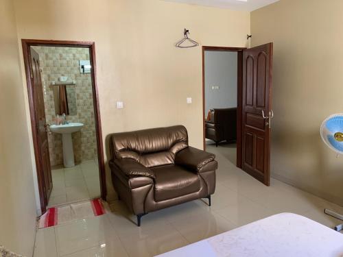 uma sala de estar com uma cadeira de couro e um lavatório em Meublé Diamniadio em Dakar