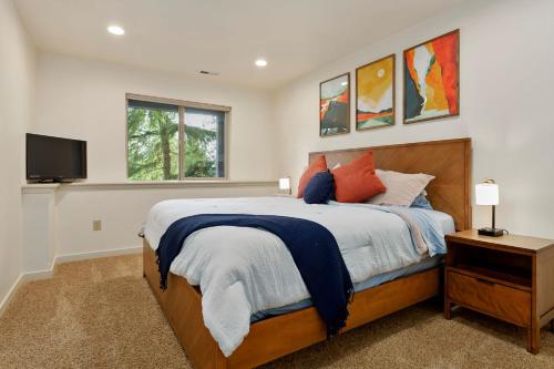 a bedroom with a bed and a tv on a wall at Modern Bellingham Retreat Near Galbraith Mountain! in Bellingham