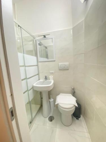 bagno bianco con servizi igienici e lavandino di Hotel Resi a Roma