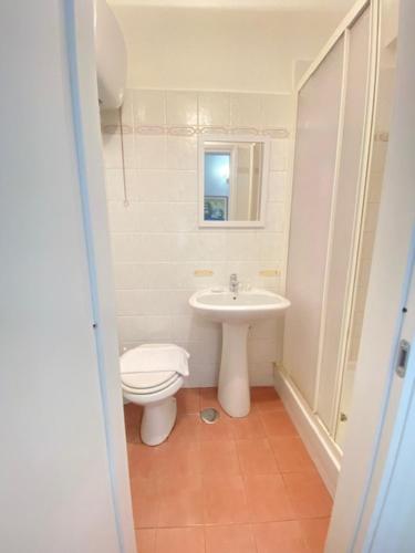 La salle de bains blanche est pourvue de toilettes et d'un lavabo. dans l'établissement Hotel Resi, à Rome