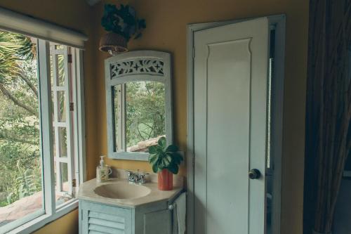 une salle de bain avec un lavabo, un miroir et une fenêtre dans l'établissement Cabaña típica Boyacense! con vista al lago y chimenea, à Paipa