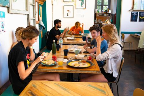 a group of people sitting at a table eating food at Madama Hostel & Bistrot in Milan
