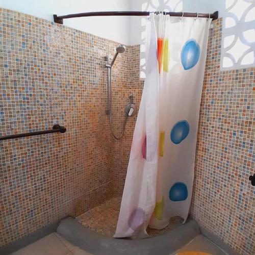 uma casa de banho com uma cortina de chuveiro em Manuastro Breeze Villa - Diani Beach em Galu