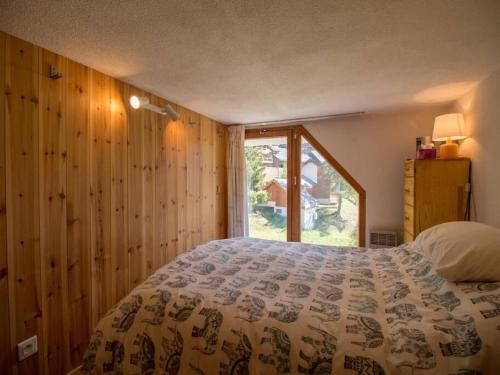 une chambre avec un lit et une grande fenêtre dans l'établissement Paradiski ski au pied vallandry, à Landry