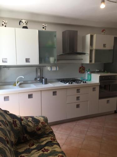 - une cuisine avec des placards blancs et un canapé dans la chambre dans l'établissement Short let SanRocco, à Olevano Romano