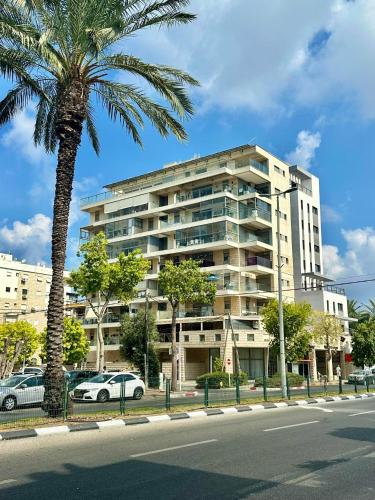 a palm tree in front of a large building at Suite In White in ‘Akko