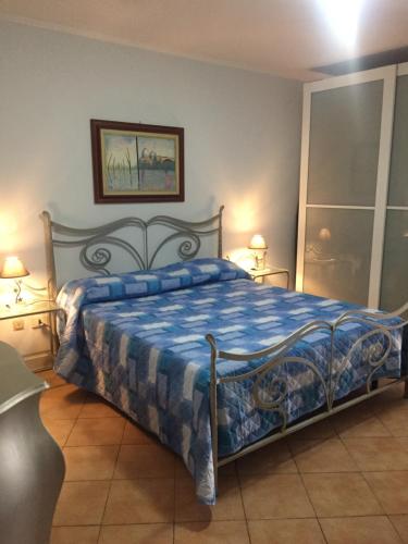 a bedroom with a bed with a blue and white blanket at Short let SanRocco in Olevano Romano