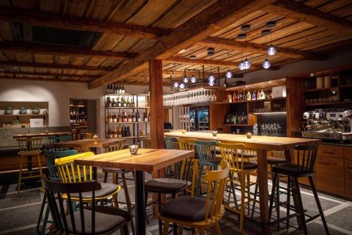 un bar con mesas de madera y sillas en un restaurante en Csello Mühle en Oslip