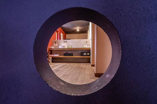 a round mirror on a purple wall with a kitchen at Hirschen Erlinsbach Swiss Quality in Erlinsbach