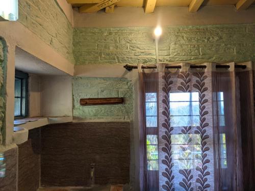 a bathroom with a window and a curtain at Manu home stay in Almora