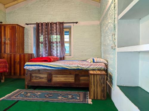 a bedroom with a wooden bed in a room at Manu home stay in Almora