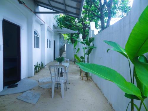 a small courtyard with two chairs and a table at Franswa Inn in El Nido