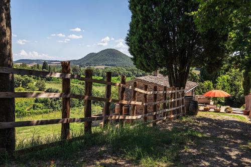 a wooden fence in front of a field at CasaMoira in Trequanda