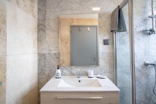 a bathroom with a sink and a shower at Madeirense Villa in Santa Cruz in Santa Cruz