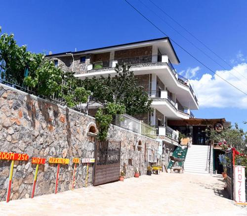 een gebouw op een heuvel met een stenen muur bij Hotel Villa Stone Dream Bar Restaurant in Pogradec