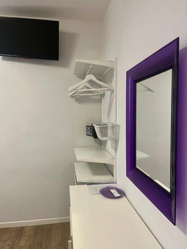 a mirror on a wall next to a white dressing room at Hotel Villa Rosa in Porto Azzurro
