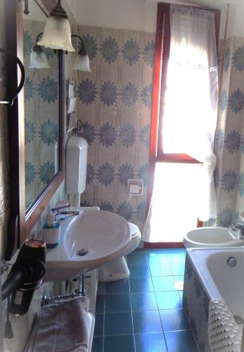 a bathroom with a sink and a toilet and a mirror at B&B L'Orchidea in Pisa