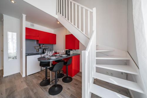 une cuisine avec des placards rouges et un bar avec des tabourets dans l'établissement Hypercentre - Palais - Croisette - Suquet - AY, à Cannes