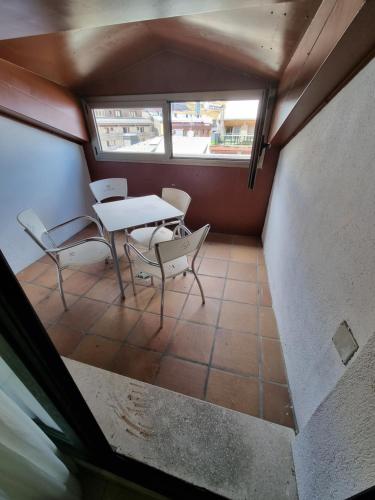 a table and chairs in a small room with a window at Hotel Cims Pas de La Casa in Pas de la Casa