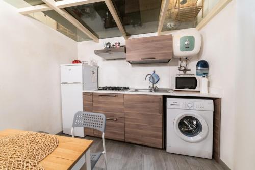 a small kitchen with a washing machine and a washer at Santa Maria degli Angeli Apartment in Naples