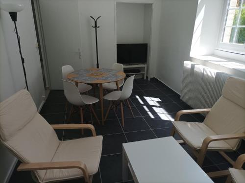 een kamer met een tafel en stoelen en een televisie bij O'Couvent - Appartement 71 m2 - 1 chambre - A222 in Salins-les-Bains