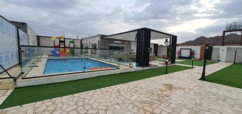 a swimming pool with a gazebo in a yard at Challet Orlando park استراحة اورلاندو in Al Mundassah