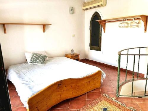 a bedroom with a wooden bed and a metal bed frame at Duplex Casa uso esclusivo Wi-Fi e spiaggia vicino in Sharm El Sheikh