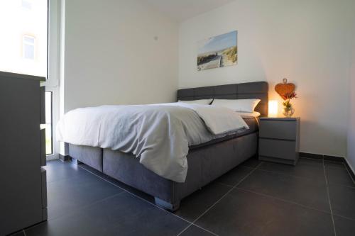 a bedroom with a bed with a white comforter on it at Modernes Ferienapartment: Komfort & Wohlfühlen in Fuldatal